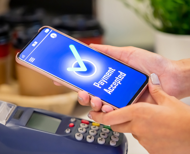 Patient using a smartphone for contactless payment at a payment terminal