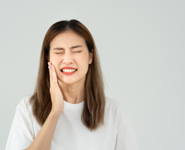 Woman holding her cheek with tooth pain that may need a root canal