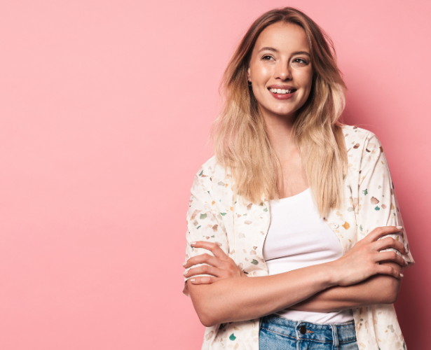 Young woman standing with folded arms and a bright smile